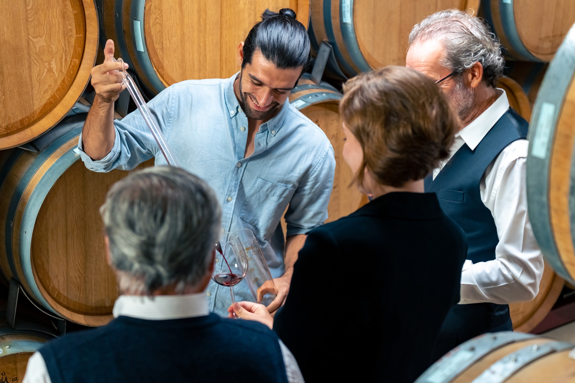 Group of People tasting wine in wine cellar.